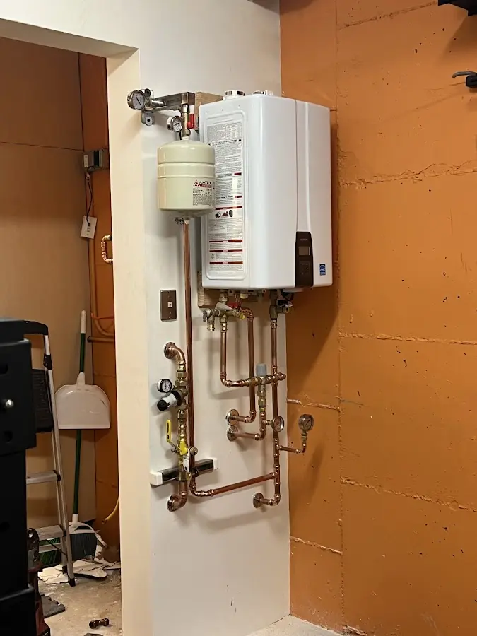 Plumbing technician inspecting water heater connections in Winthrop